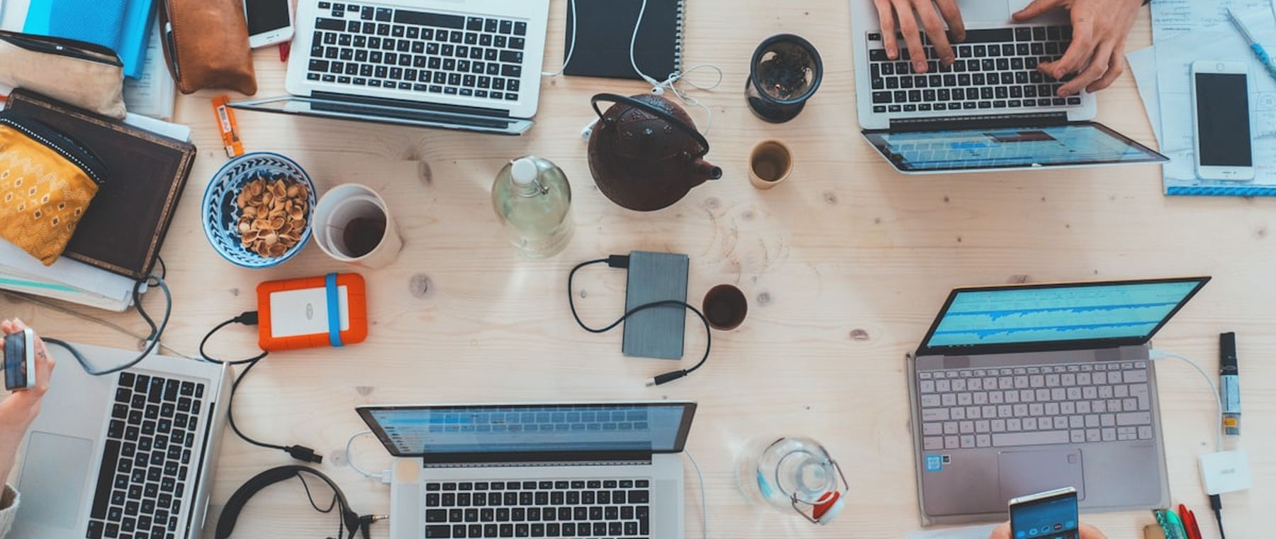 Werkplek van bovenaf met laptops en aantekeningen