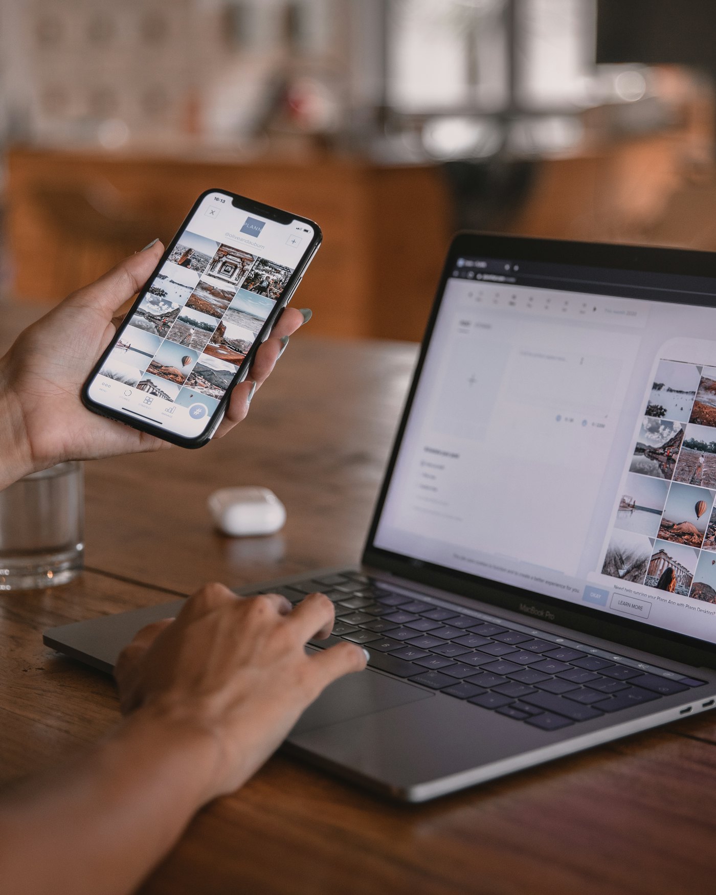 Iemand bekijkt een website op de telefoon, met de laptop ernaast